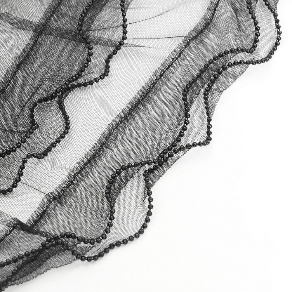 Close-up of black tulle fabric with ruffled edges and beaded details, perfect for gothic fashion accents.