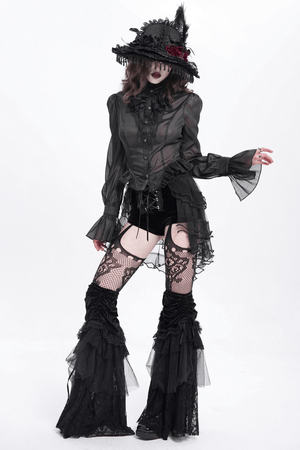 Mystical model in edgy gothic outfit with lace details, black ruffled shorts, and dramatic hat showcasing alternative fashion.