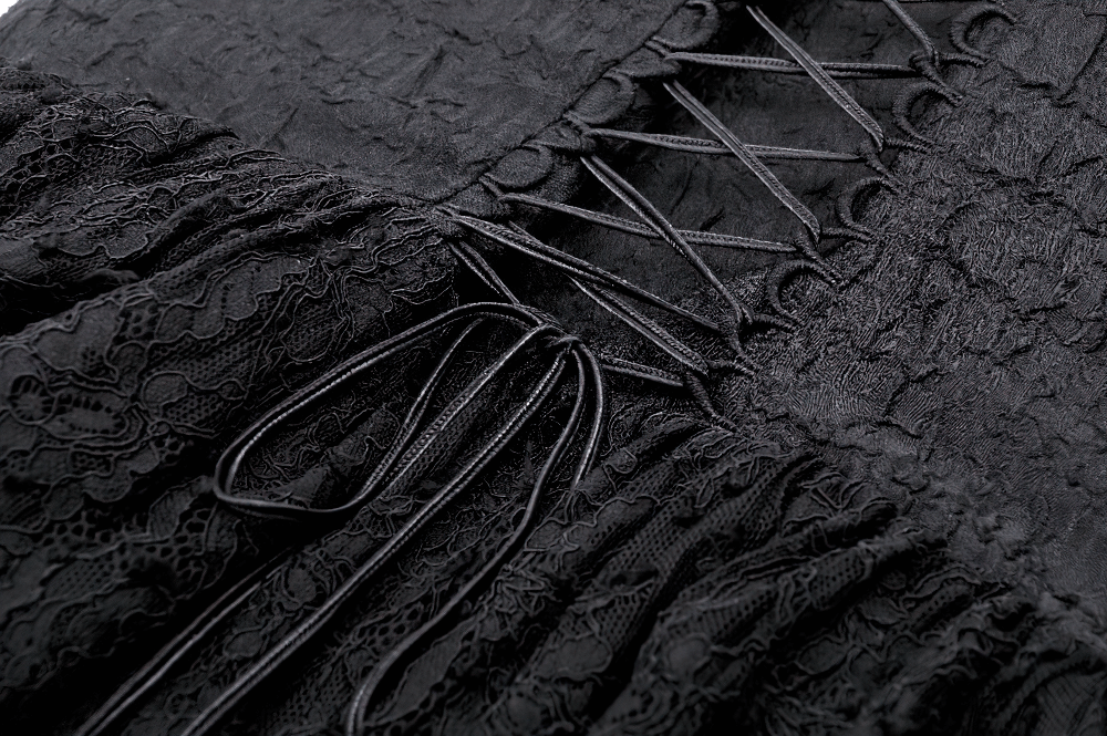 Close-up of Gothic lace-up black corset bodice with tulle skirt, showcasing elegant details and textures.