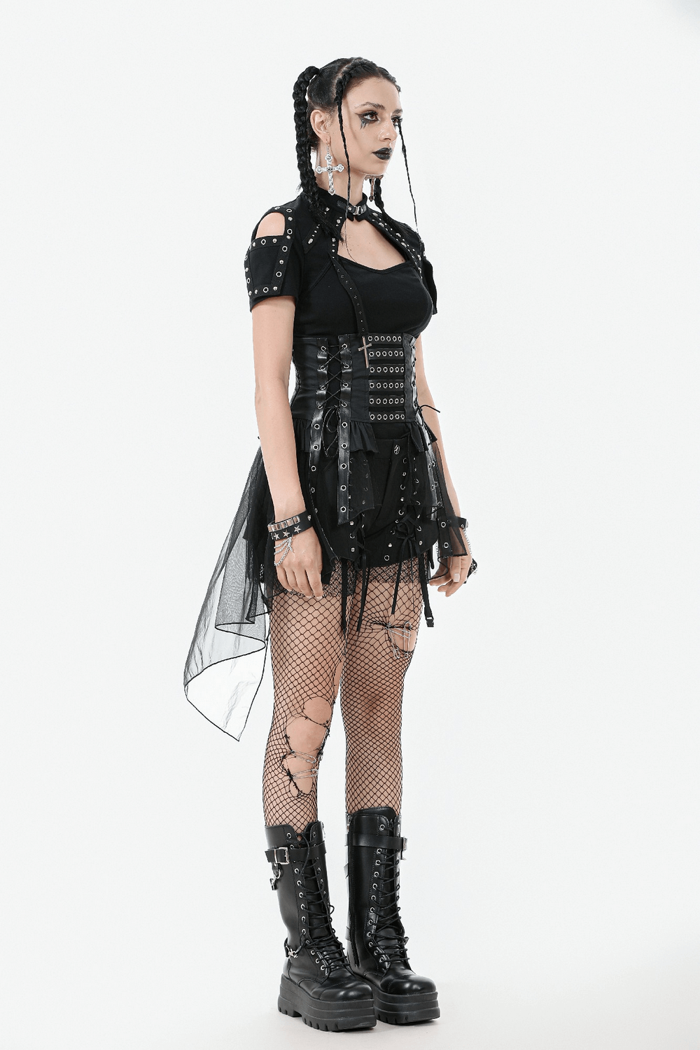 Dark goth model wearing a lace-up corset belt and layered tulle skirt, featuring fishnet tights and chunky platform boots.