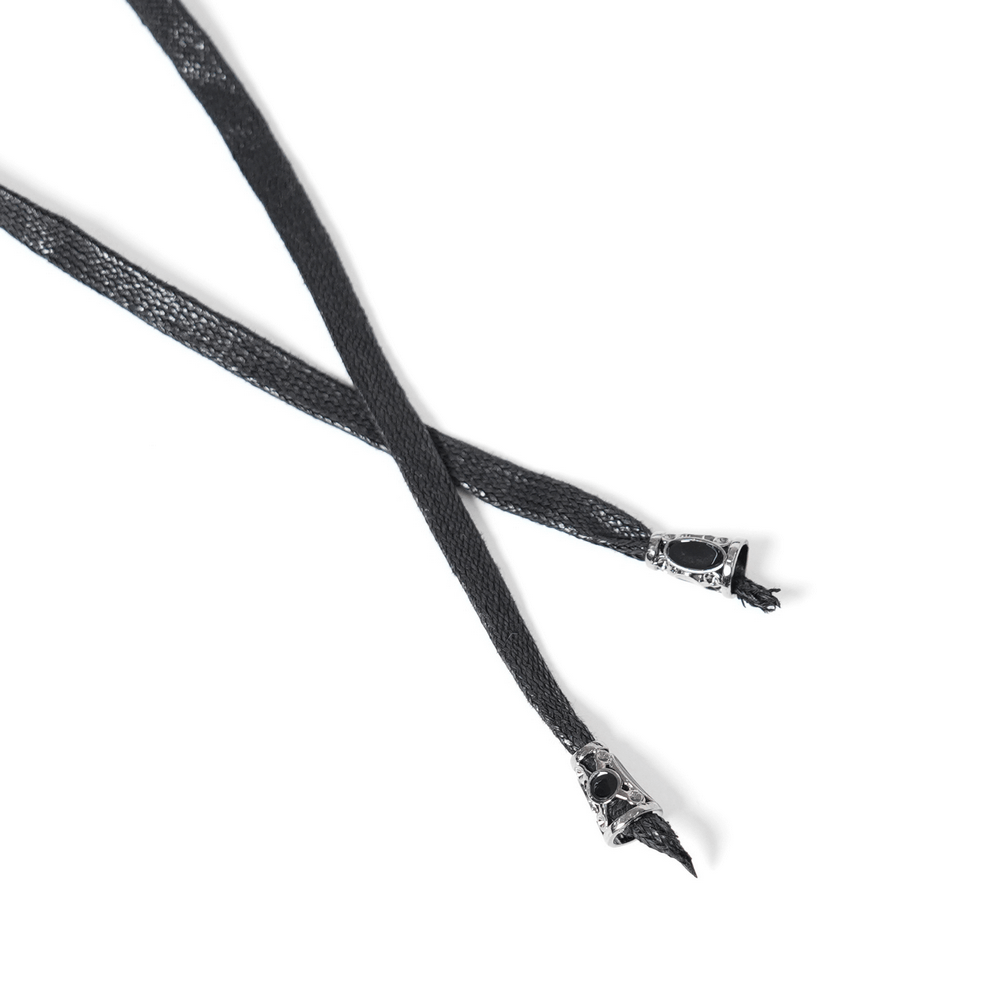 Close-up of black lace corset laces with decorative metal tips for gothic fashion.