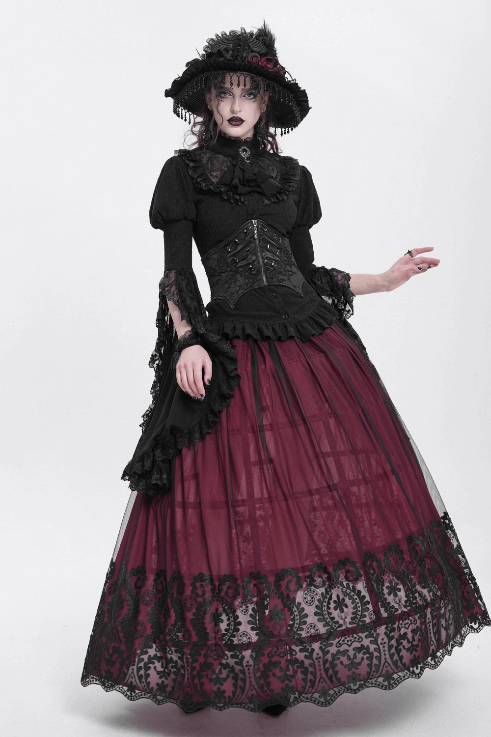 Model wearing a gothic lace-up corset belt with a dark skirt, lace details, and a stylish hat in a dramatic pose.