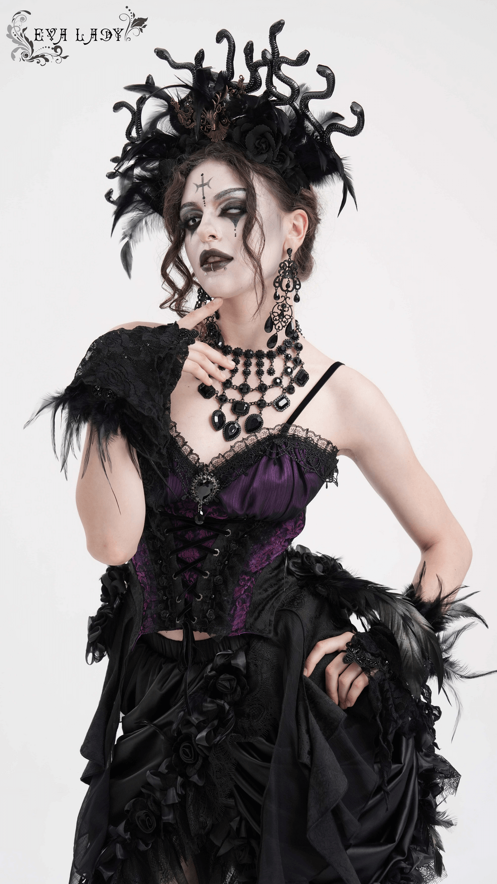 Model showcasing Gothic lace-up corset top in purple and black, adorned with dramatic accessories and floral details.