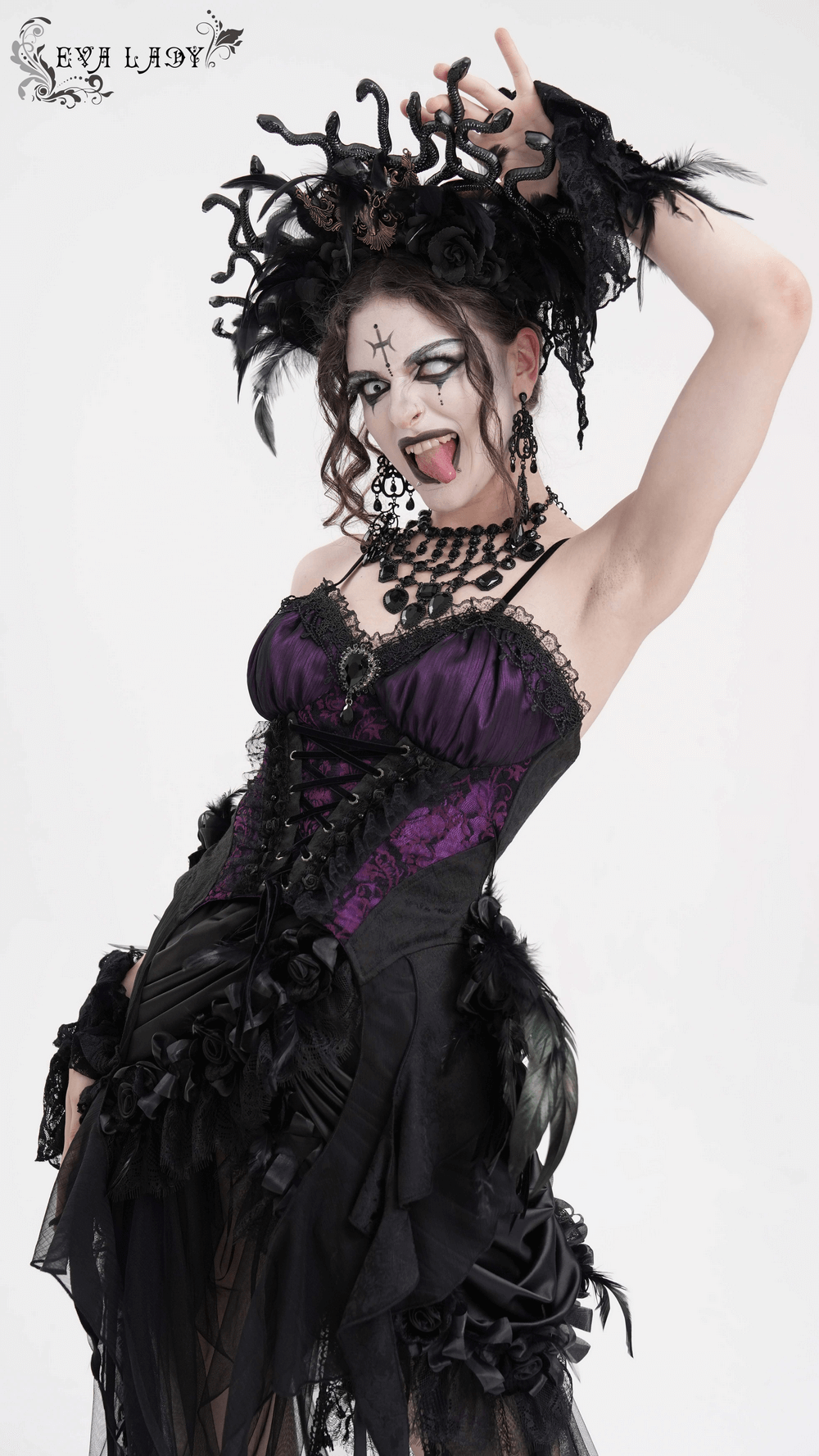 Gothic model in purple and black lace-up corset top, showcasing floral accents and dramatic accessories, exuding Victorian elegance.