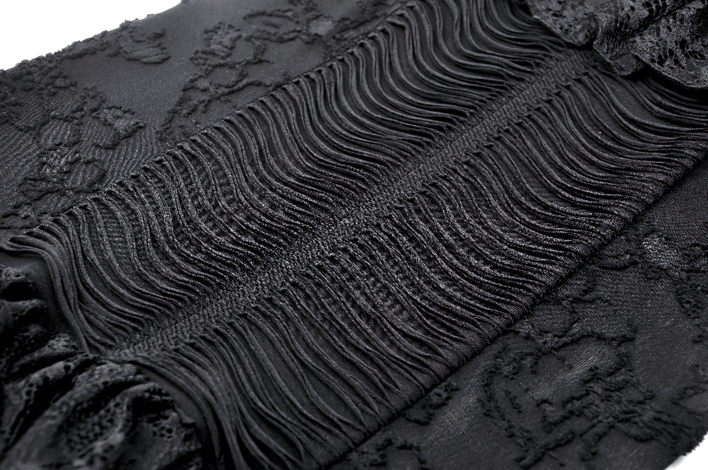 Close-up of gothic lace detailing and ruffled fabric on a black dress, showcasing intricate textures and patterns.