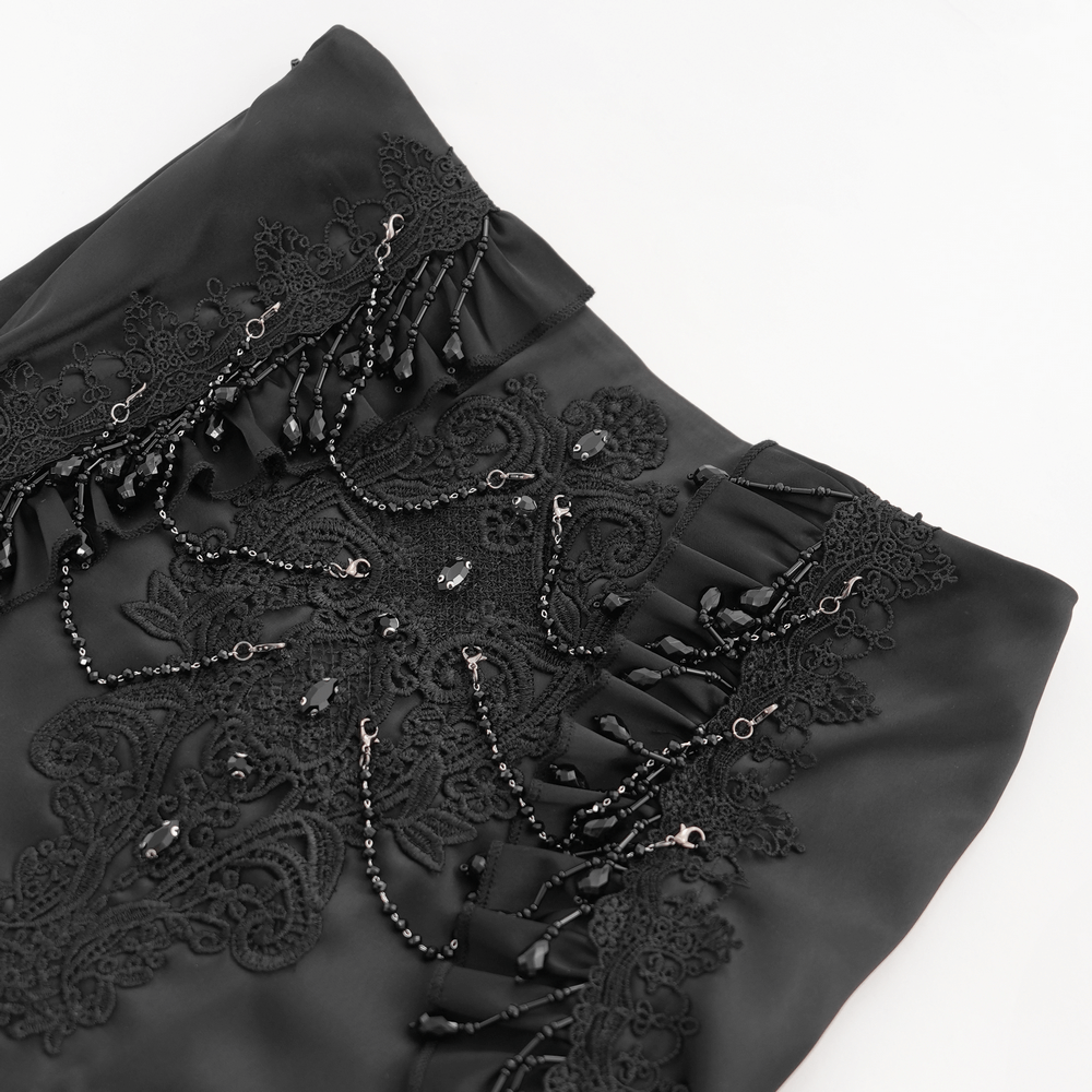 Close-up of gothic black skirt with lace, fringe, and bead embellishments for a dramatic look.