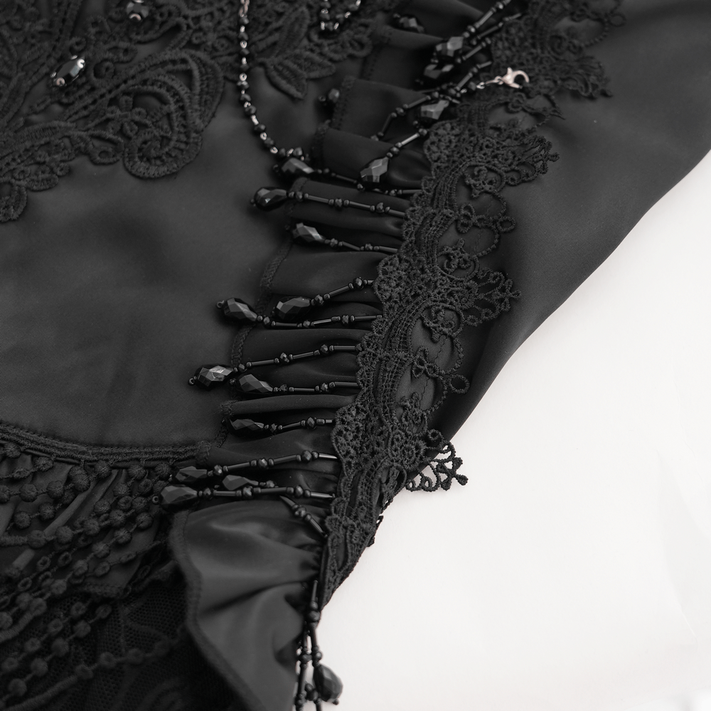 Close-up of gothic black skirt's lace-up fringe and intricate floral embroidery with bead details.