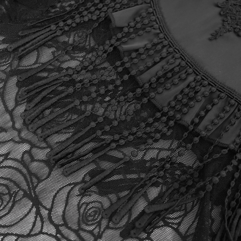 Detailed view of lace fringe and floral embroidery on a gothic black skirt.