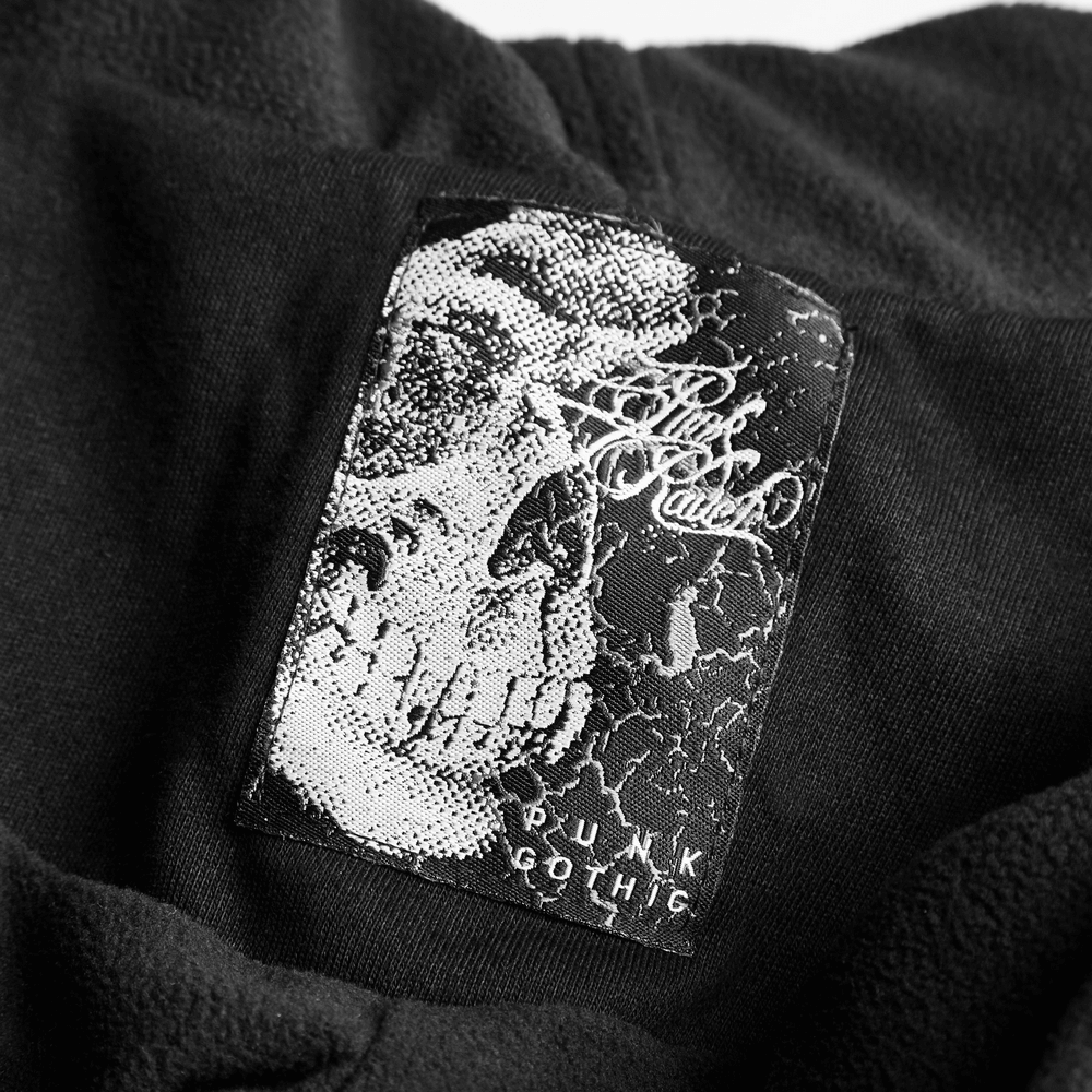 Close-up of a punk gothic label featuring a skull design on a black fabric background.