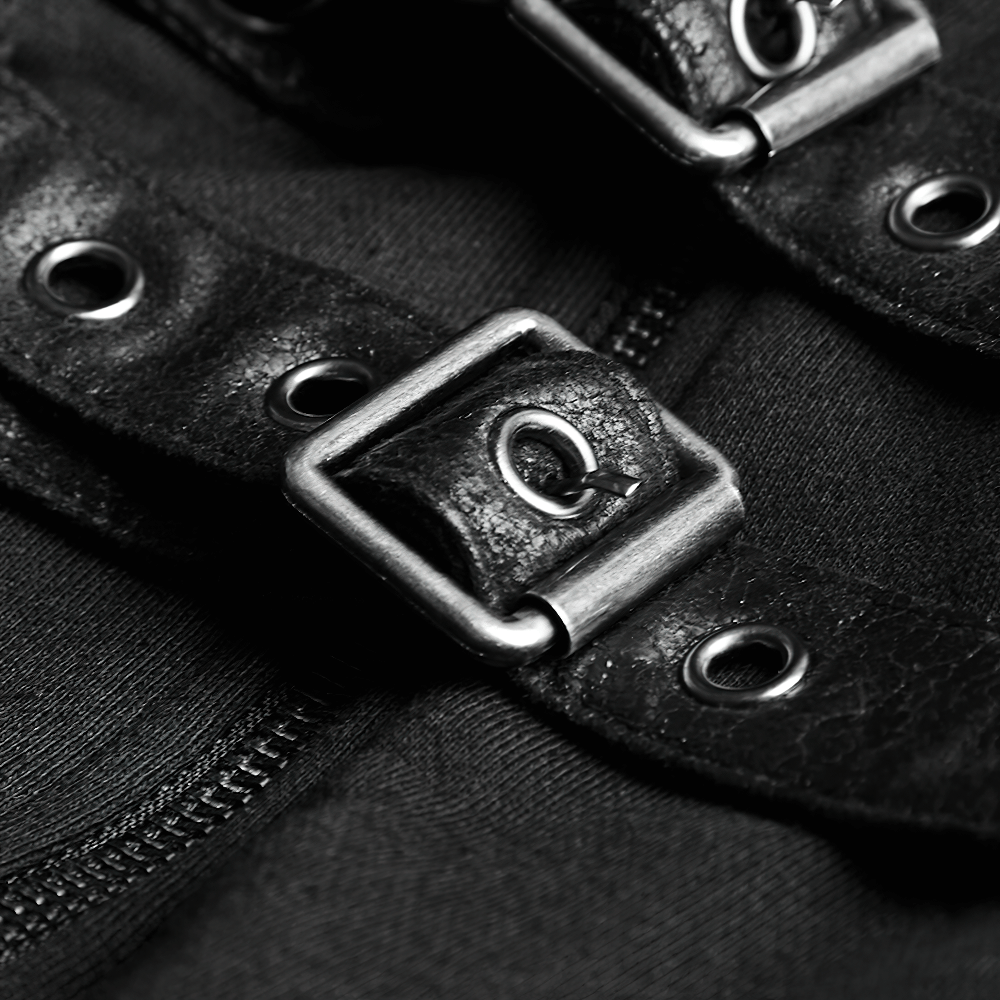 Close-up of faux leather buckles and metal grommets on a gothic-inspired long coat.