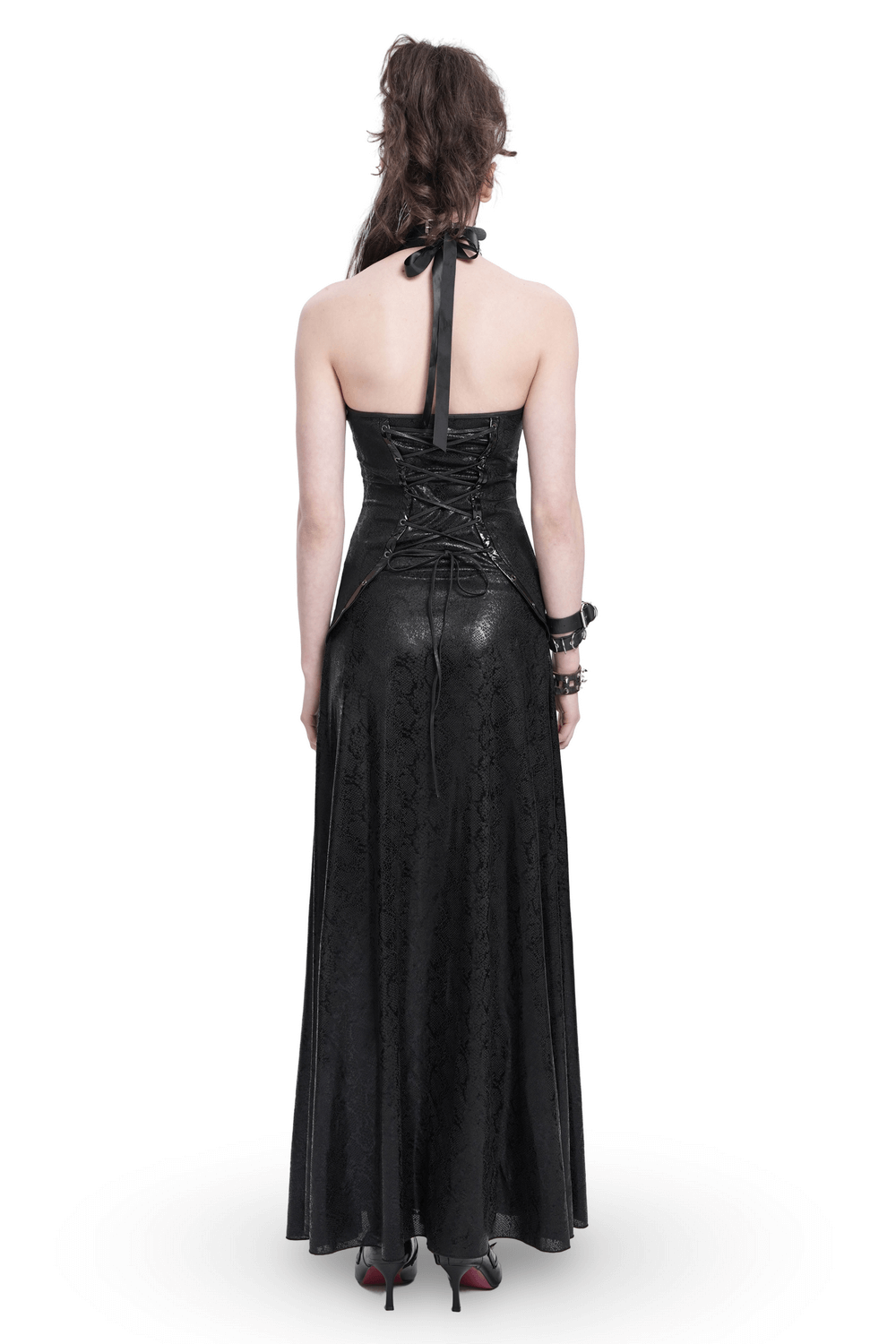 Back view of black gothic lace-up maxi dress with halter neck and corset details, showcasing flowing skirt and edgy design.