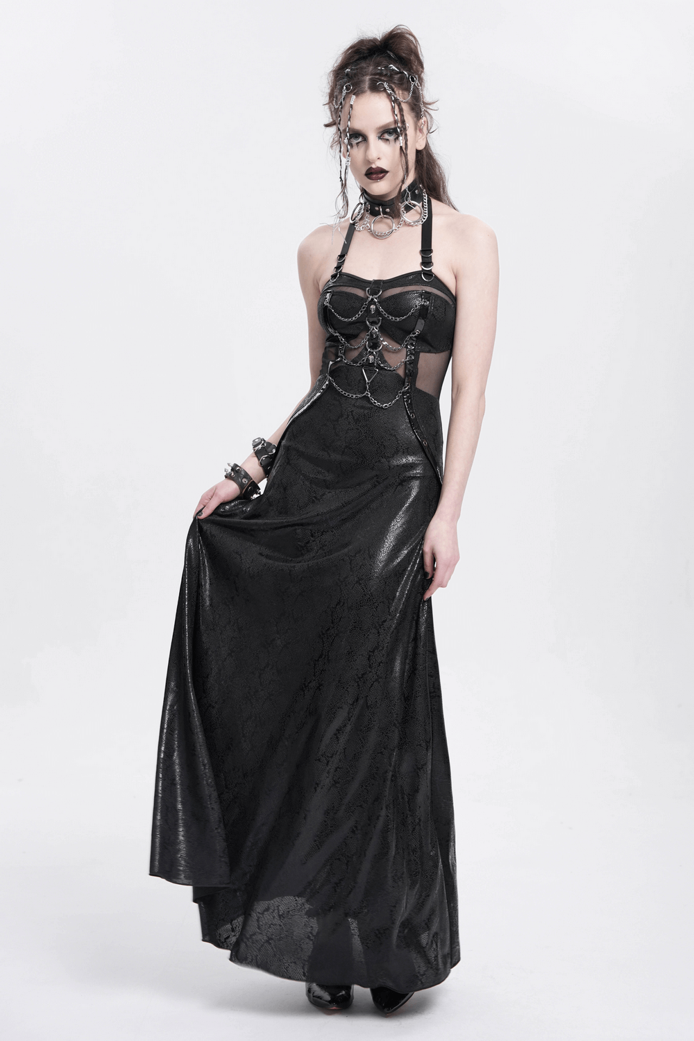 Gothic lace-up maxi dress with chains and cutouts, featuring a halter neckline and dramatic flowing skirt.