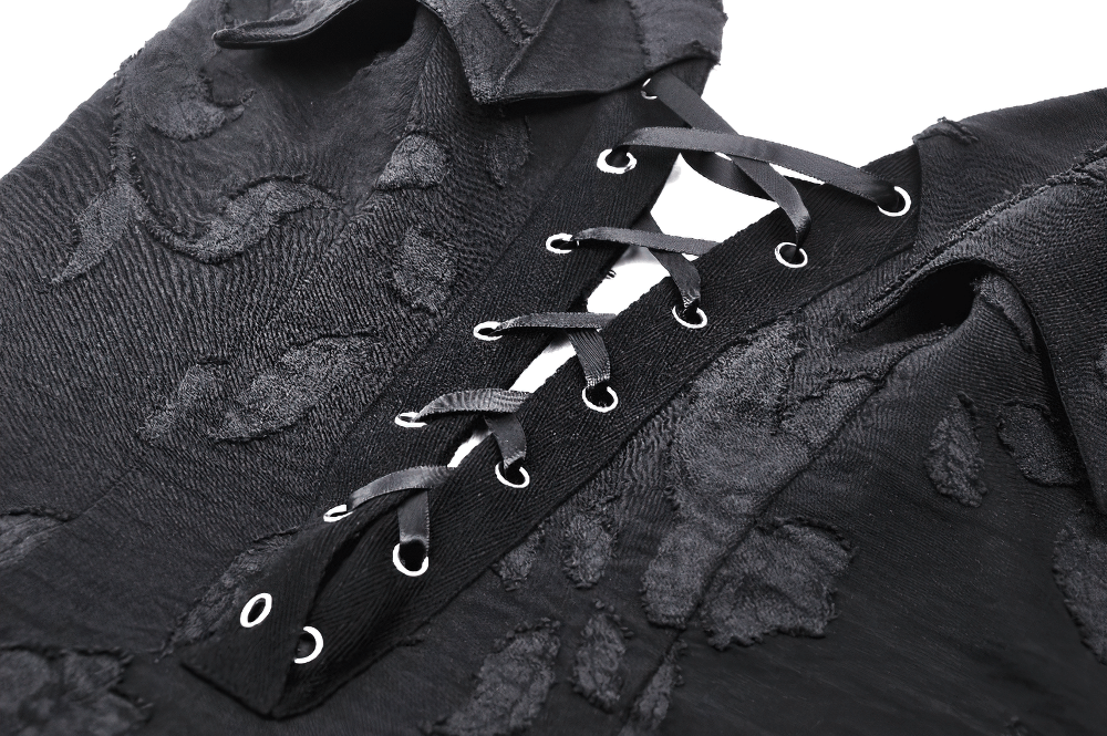Close-up of Gothic lace-up black dress showcasing intricate lace-up detail and textured floral fabric.