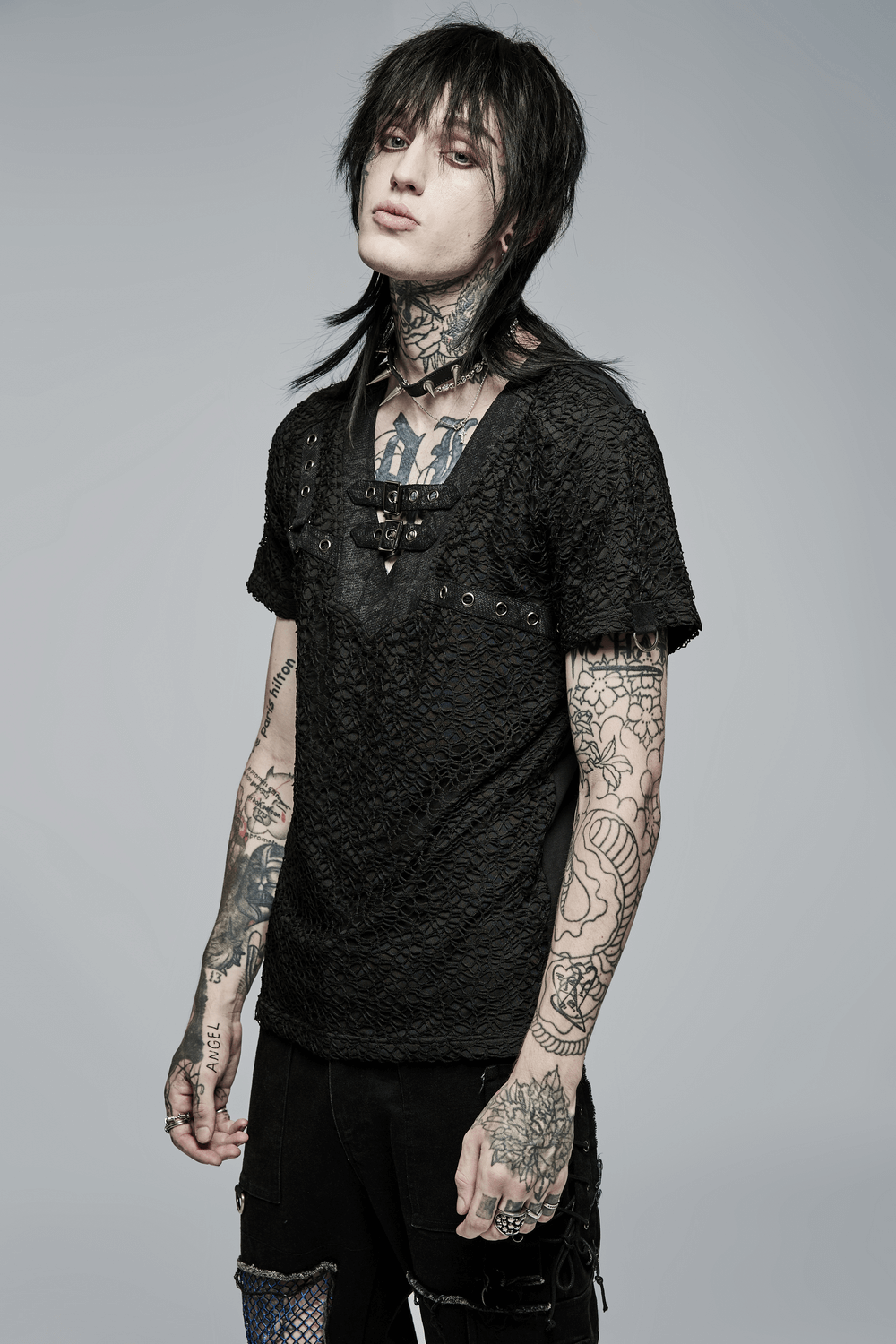 Edgy gothic model showcasing a lace-up V-neck mesh tee with tattoos and stylish short sleeves.