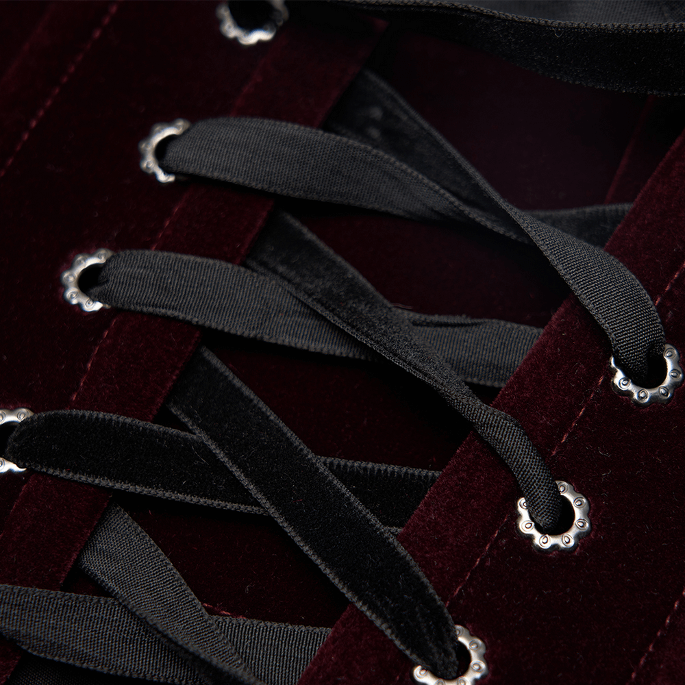 Close-up of Gothic corset's velvet lace-up detailing with black satin ribbons and decorative silver eyelets.