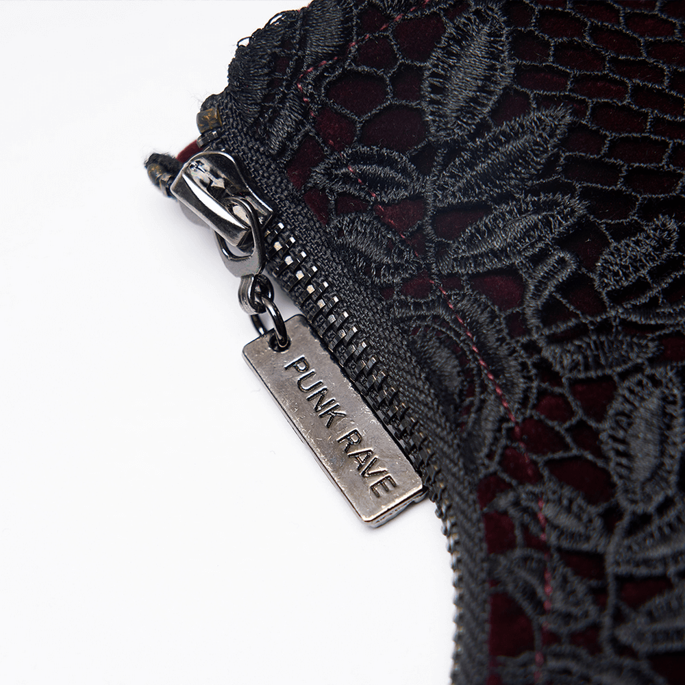 Close-up of a zipper with a 'PUNK RAVE' tag on a gothic lace-up velvet corset with red accents.