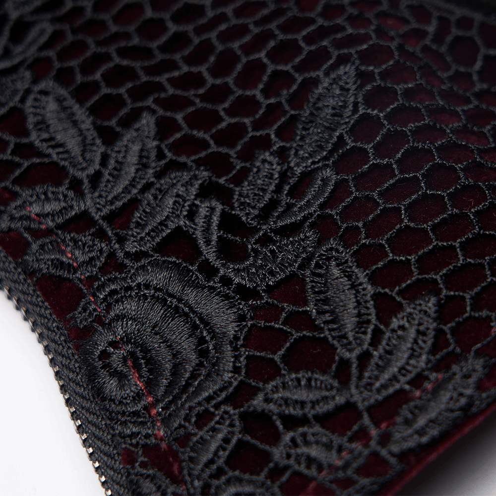 Close-up of gothic lace design on plush velvet corset with rose accents, showcasing intricate embroidery.