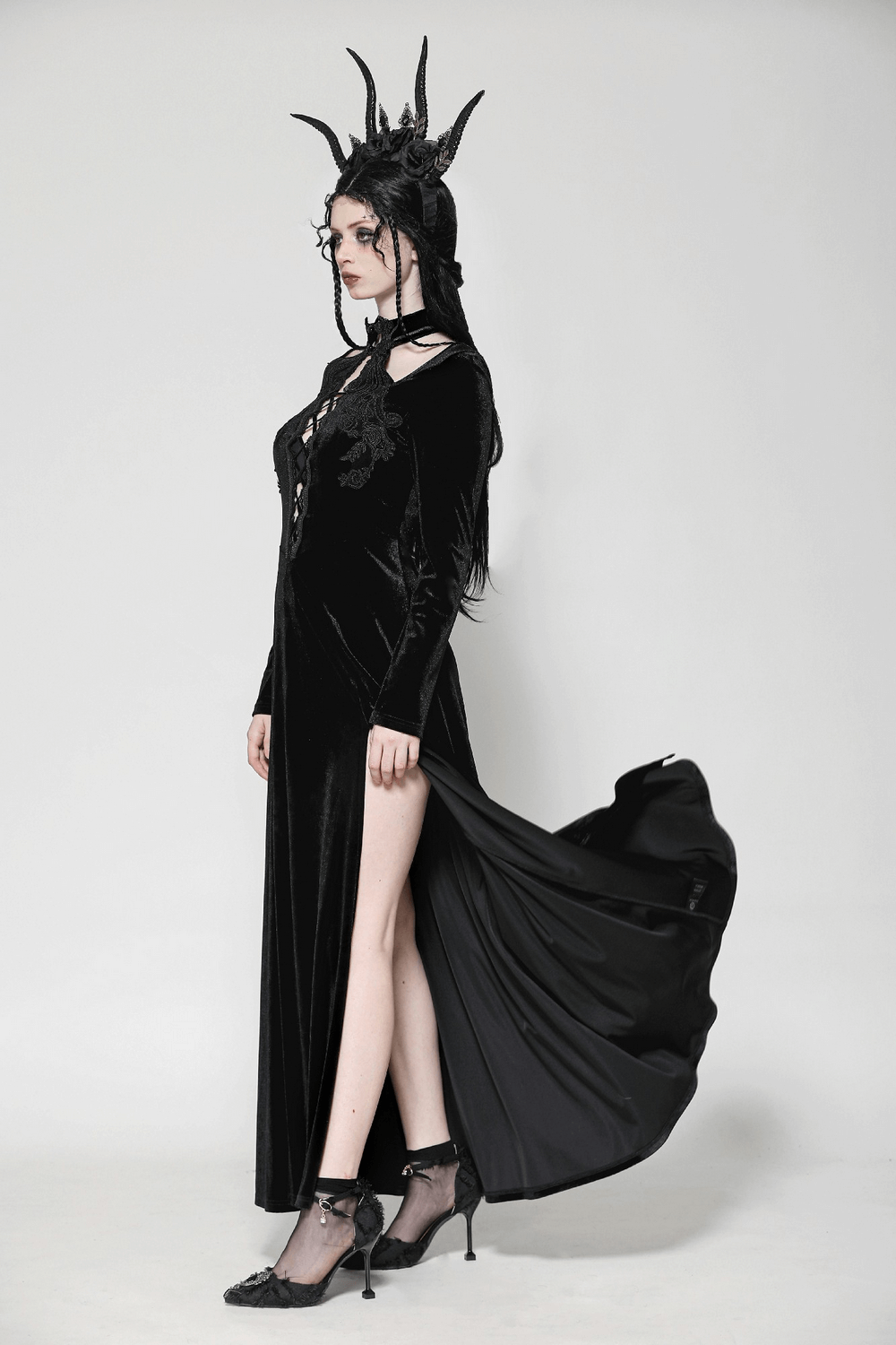 Gothic lace-up velvet dress with ruffled details and slit, showcasing a dramatic silhouette and dark elegance.