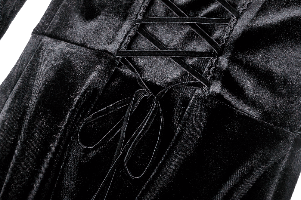 Close-up of gothic lace-up velvet dress showcasing ruffled details and elegant black fabric.