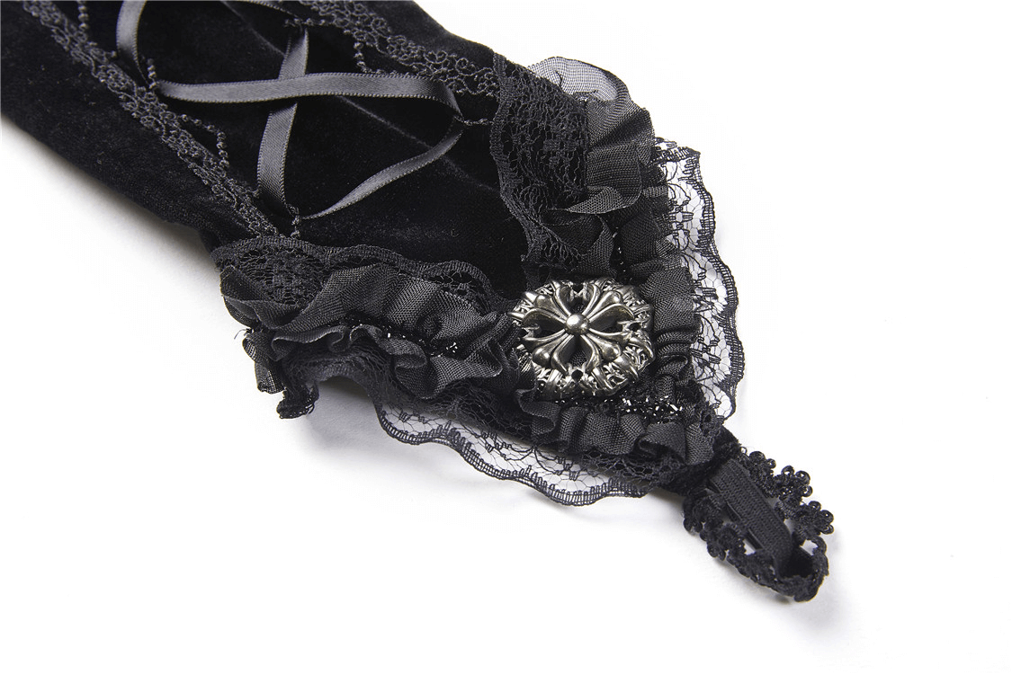 Close-up of gothic black lace-up velvet fingerless glove with intricate lace and decorative embellishments.