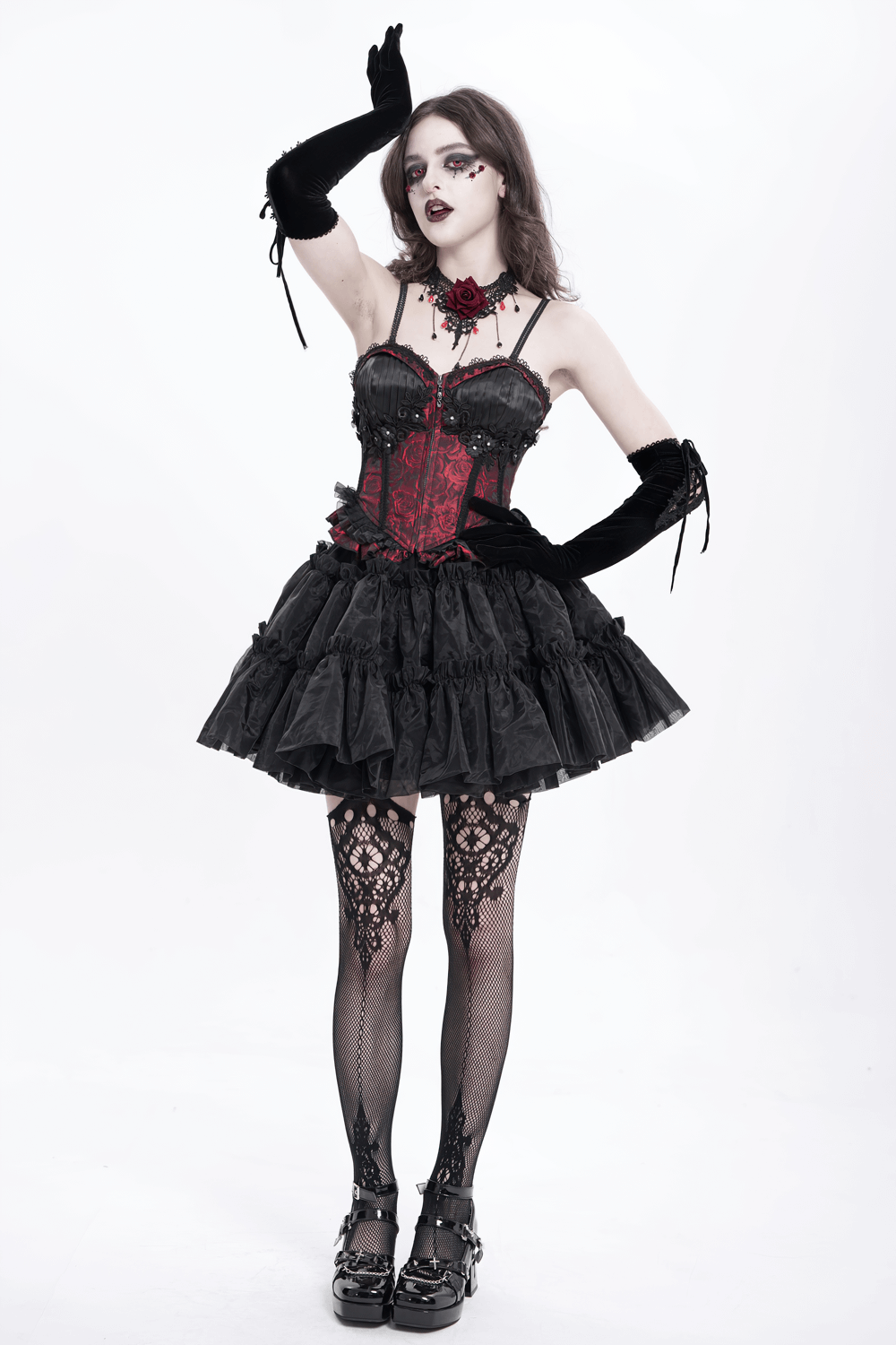 Gothic model in wine red lace-up corset with ruffle skirt, black gloves, and intricate lace stockings.