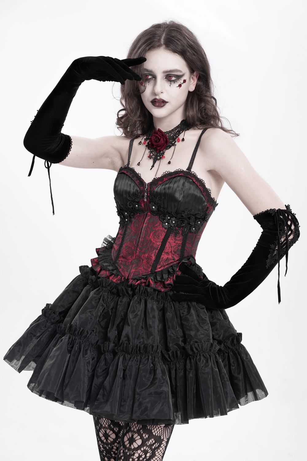 Gothic model in wine red lace-up corset with ruffle trim, black skirt, and accessories showcasing elegant rebellion.