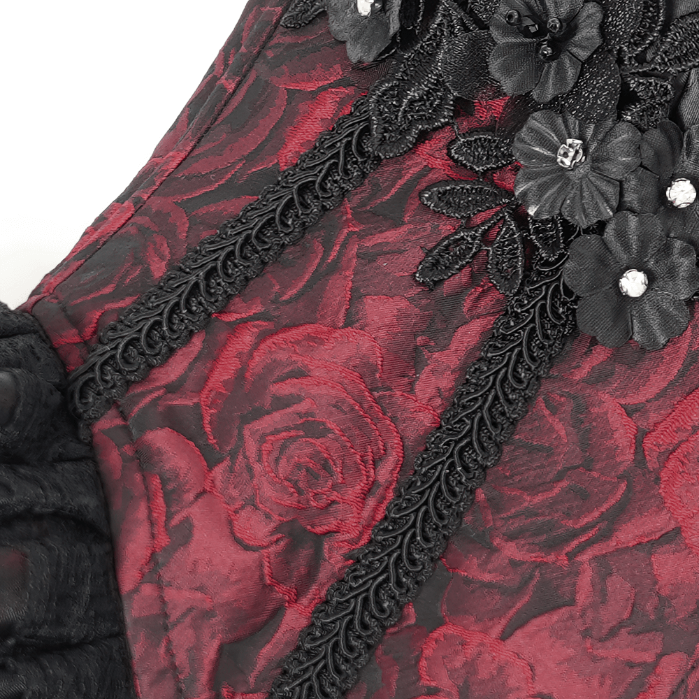 Close-up of wine red gothic lace corset with ruffled trim and floral embellishments, showcasing intricate lace details.
