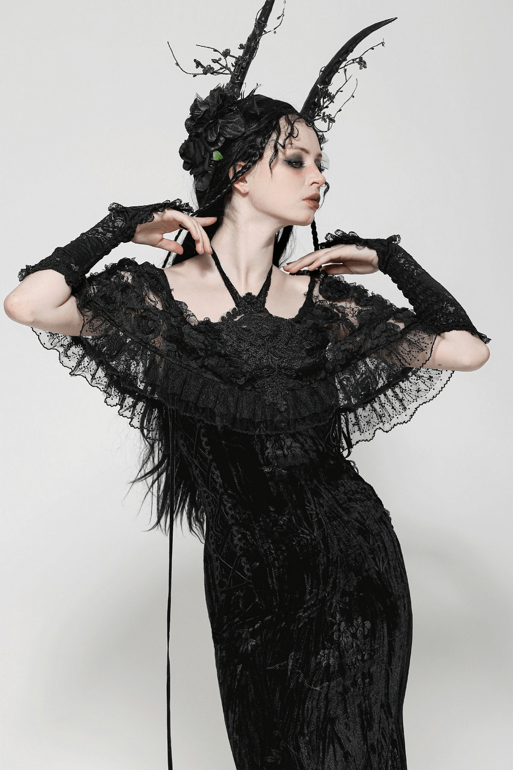 Elegant model in Gothic lace velvet maxi dress with ruffled hem, lace sleeves, and dark accessories.