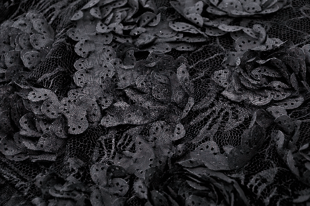 Close-up of black lace fabric featuring floral patterns, perfect for gothic designs and elegant attire.