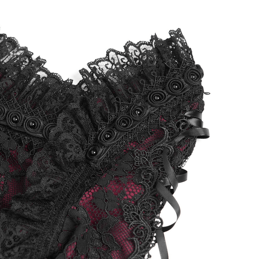 Close-up of black gothic lace detailing with buttons and ribbons on a wine red mini dress.