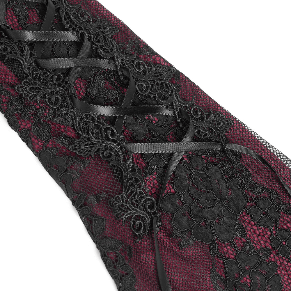 Close-up of gothic lace detailing in wine red and black fabric, featuring lace-up accents and floral patterns.