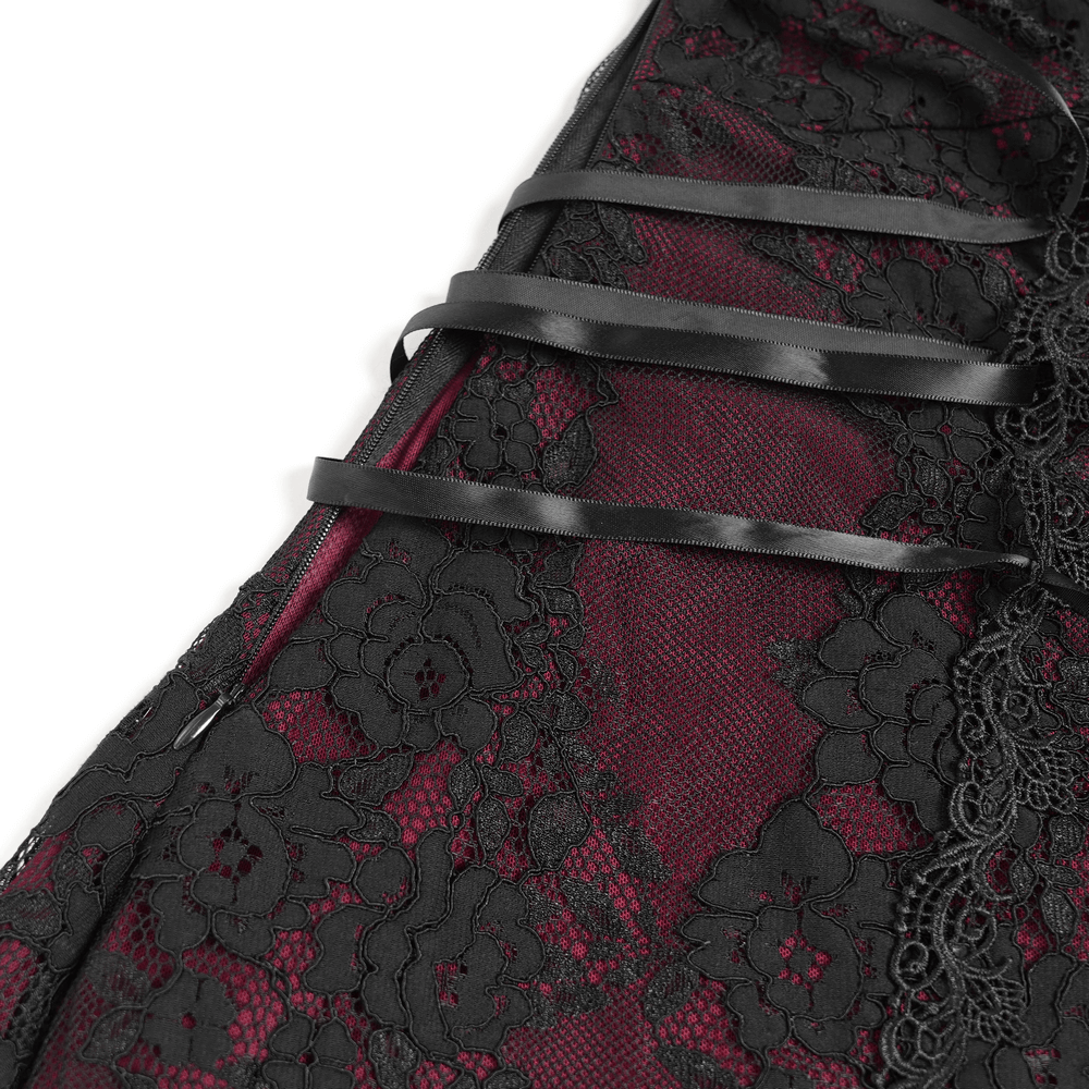 Close-up of gothic lace and ribbon detailing on wine red and black mini dress.
