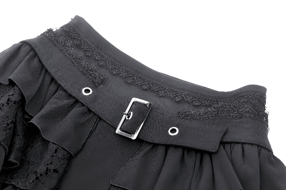 Close-up of black gothic mini skirt waistband with layered ruffles, lace trim, and silver buckle detailing.