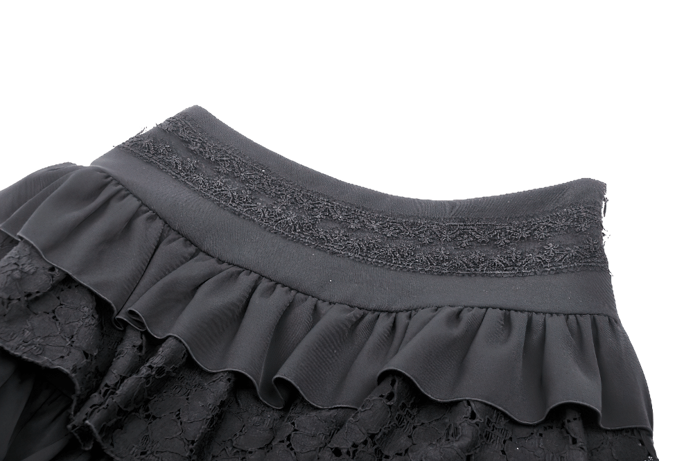 Close-up of gothic black mini skirt with layered ruffles, lace details, and decorative waistband.