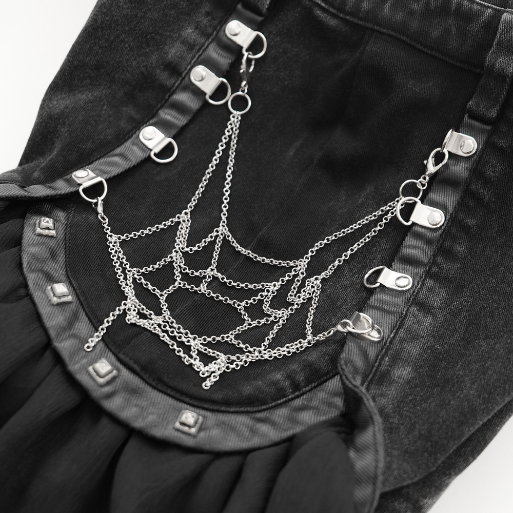 Close-up of gothic layered shorts featuring decorative chain spiderweb details and studs for an edgy look.