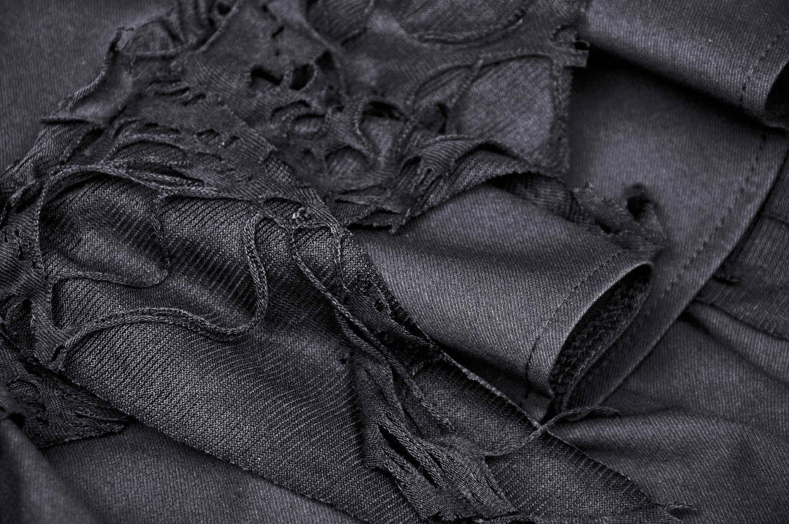 Close-up of black fabric details featuring lace and ruffles for a gothic layered skirt, showcasing texture and design.