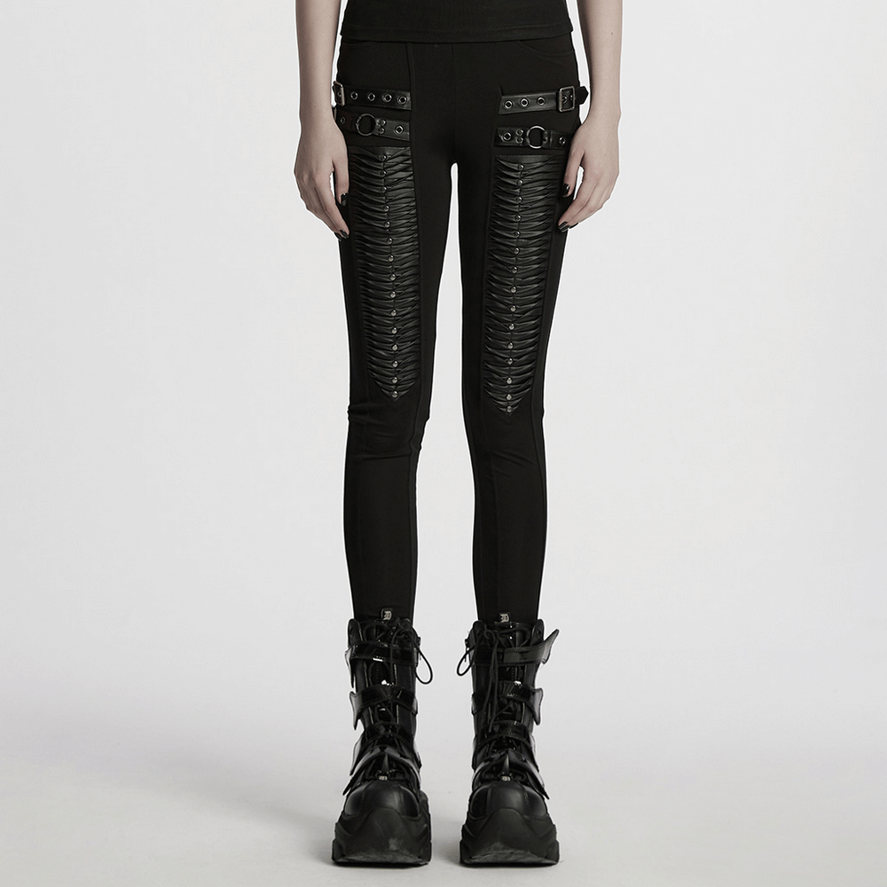 Gothic leggings featuring 3D pleats and faux leather straps, styled with edgy boots on a model.