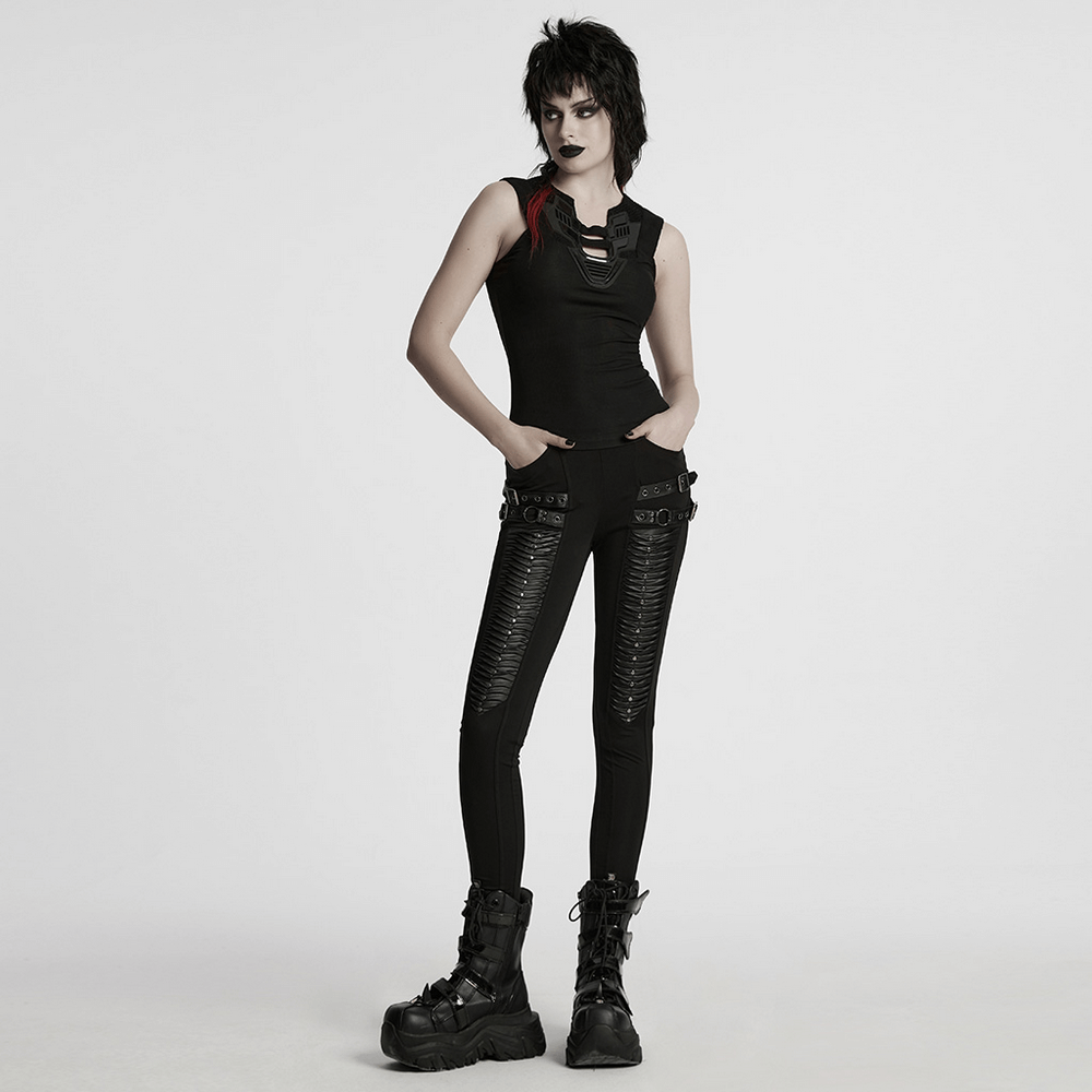 Gothic leggings with 3D pleats and faux leather straps, styled with a matching black top and edgy fashion boots.