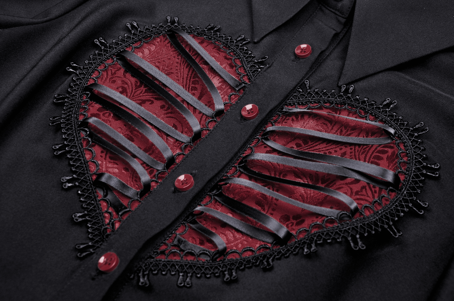 Close-up of Gothic Lolita black dress featuring a red heart lace detail with buttons and elegant ribbon accents.