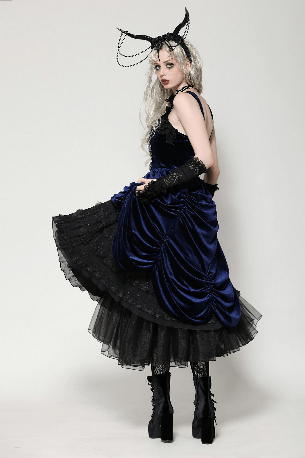 Model showcasing a Gothic Lolita dress in black and navy velvet with ruffled lace and elegant accessories.