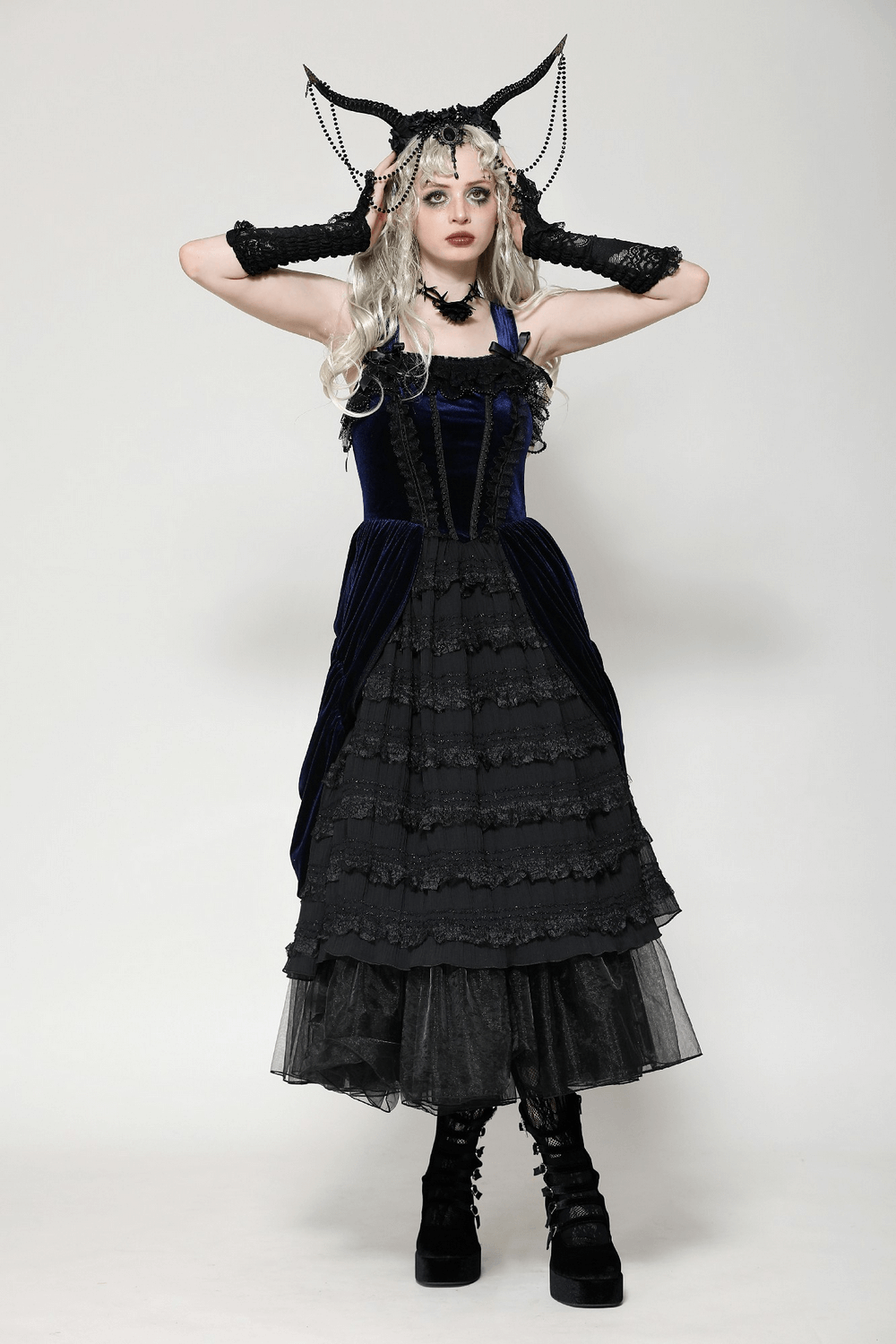 Model showcasing a Gothic Lolita dress with ruffled lace and adjustable straps, styled with unique accessories and dramatic makeup.