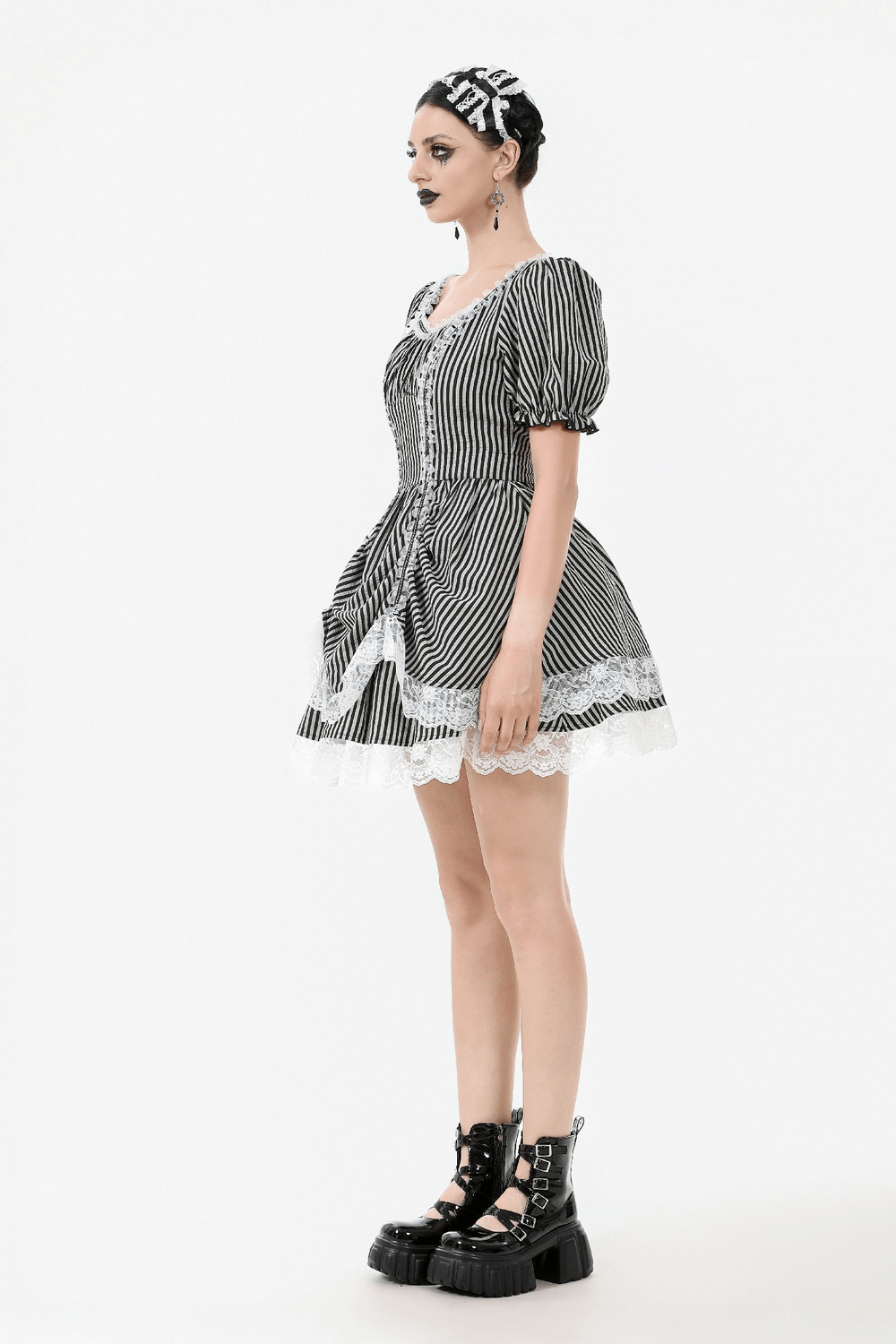 Model wearing a Gothic Lolita dress with black and white stripes, puff sleeves, lace trim, and platform boots.