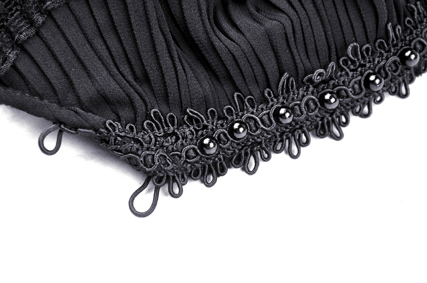 Close-up of black fabric with frilly beads and intricate ruffle detailing for gothic lolita style coat.