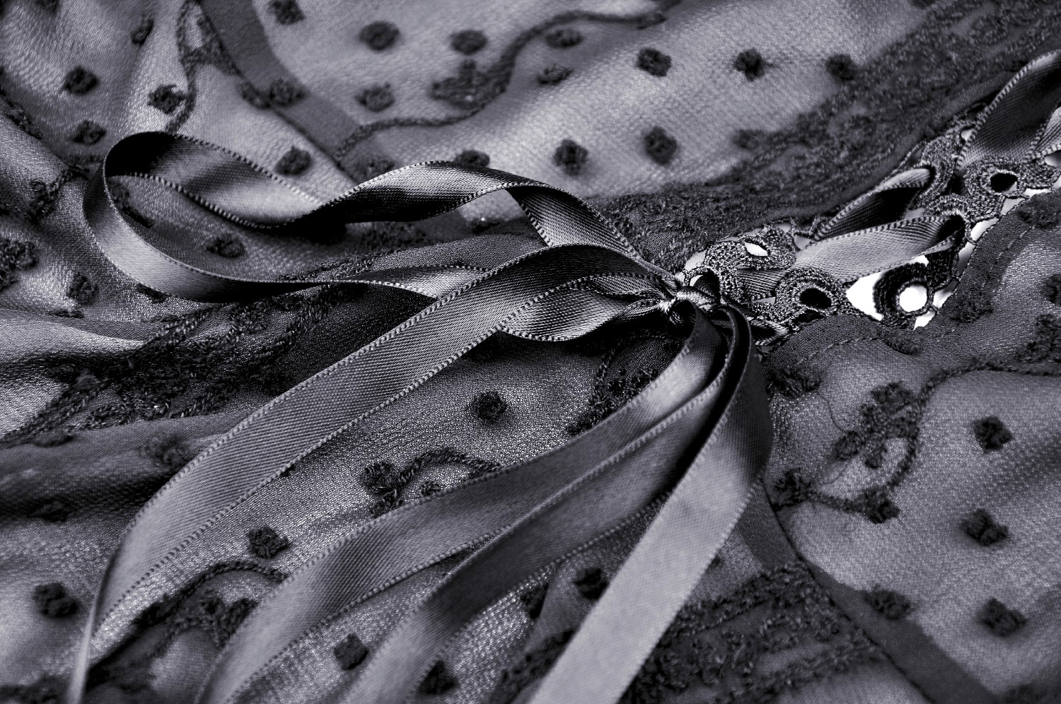 Close-up of a Gothic Lolita coat featuring delicate frills, intricate beads, and elegant ribbons in black fabric.