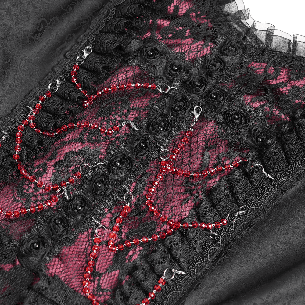 Close-up of gothic lace dress featuring black lace, red accents, and intricate detailing for a medieval-inspired look.
