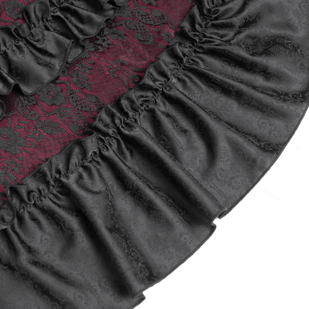 Close-up of the intricate black lace and red ruffled hem of a gothic medieval dress.