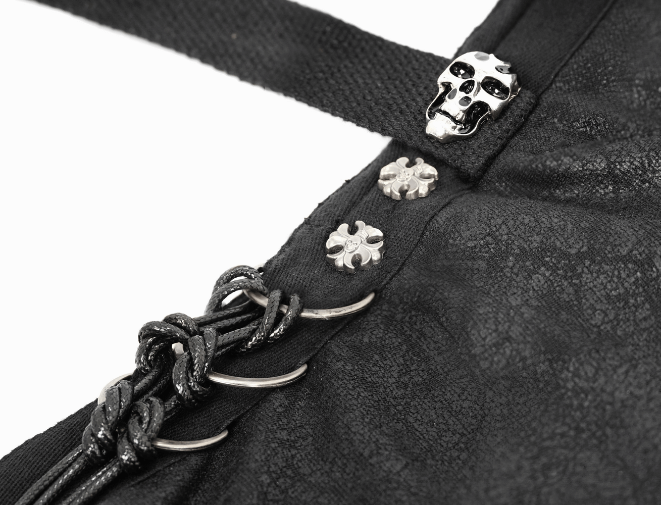 Close-up of gothic cloak details featuring skull and decorative buttons for a dark, elegant look.