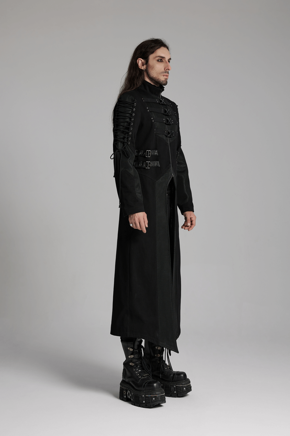 Gothic long coat with X-buckles and mesh accents, showcasing a punk aesthetic on a model wearing platform boots.