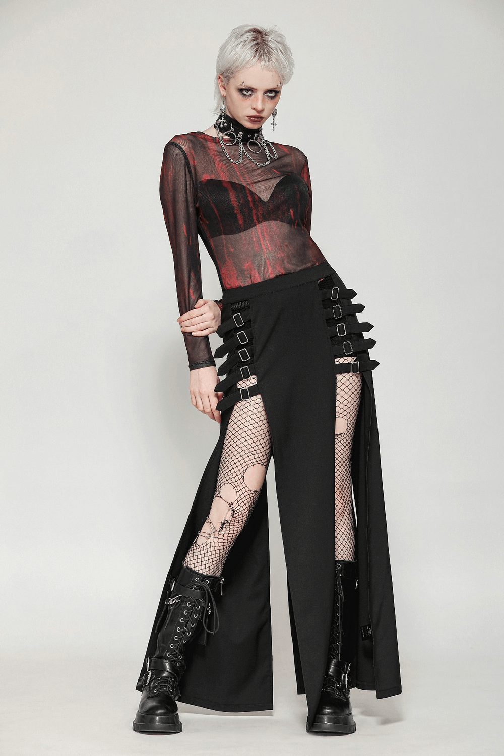 Gothic long skirt with side cutouts and buckle straps, styled with a sheer shirt and fishnet stockings.