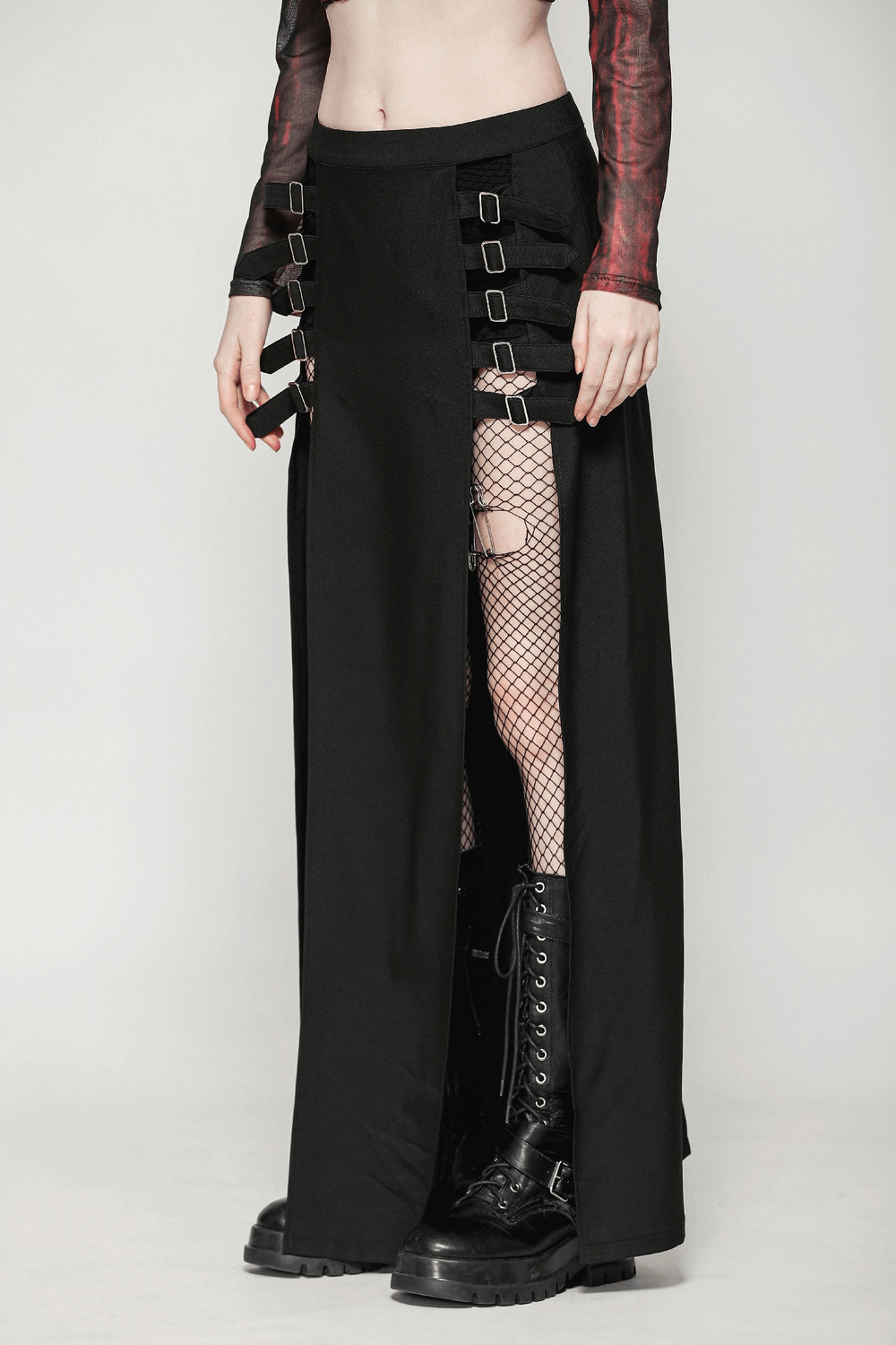 Gothic long skirt featuring side cutouts and buckle straps, styled with fishnet tights and combat boots.